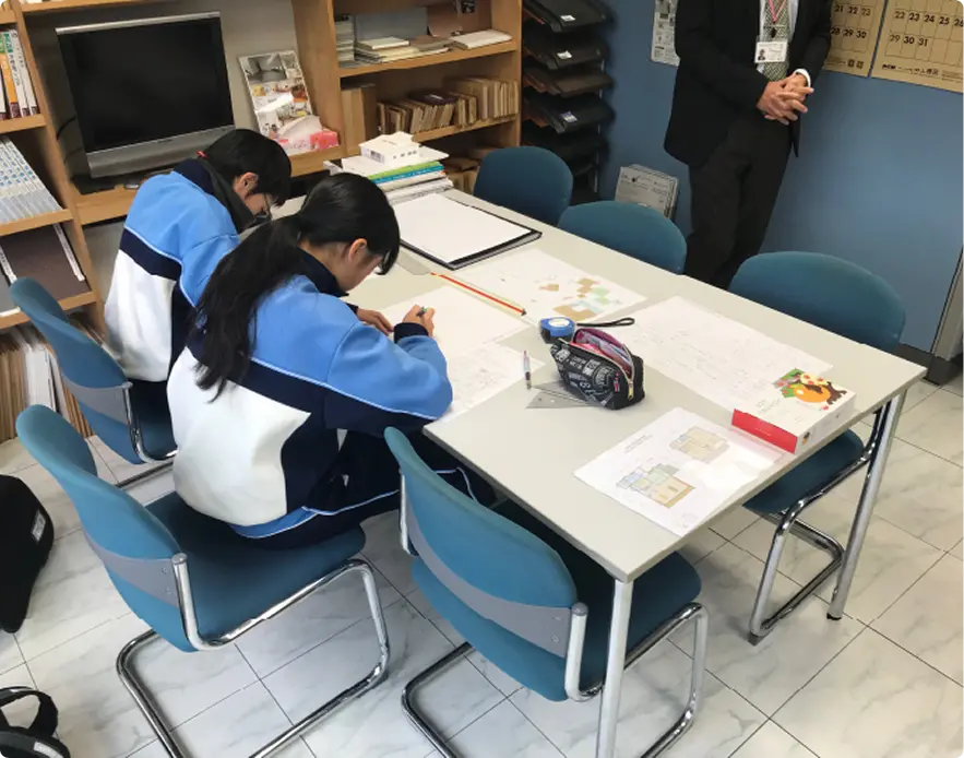 子供2人に家の設計図を説明している