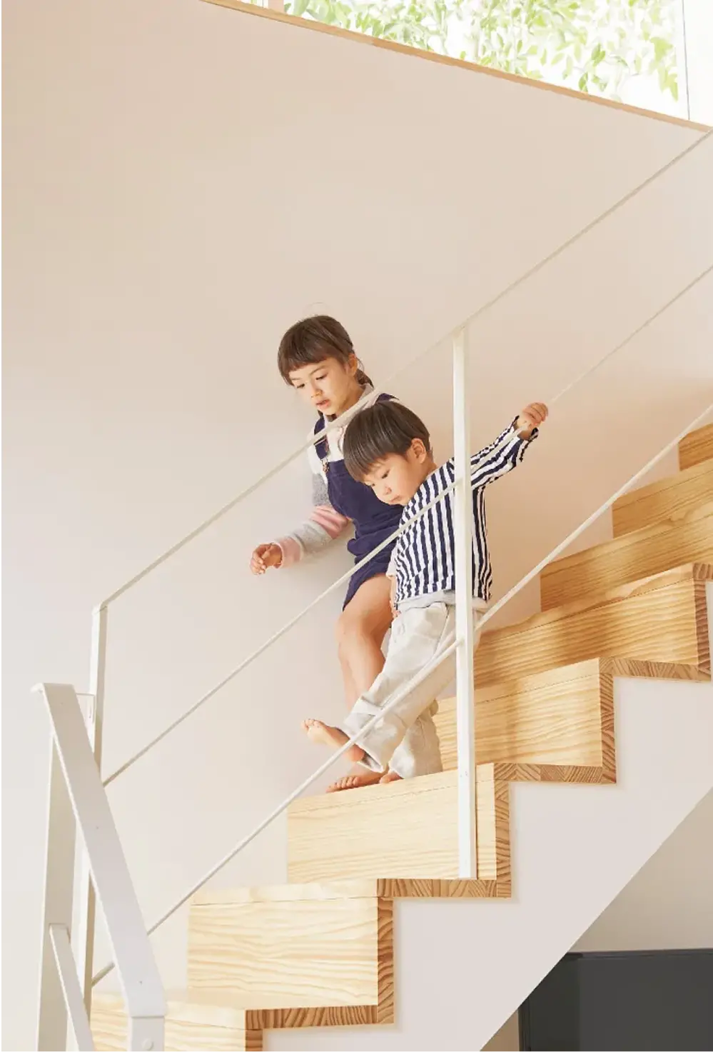 男の子と女の子とが階段を降りている